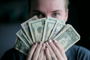 person holding fan of U.S. dollars banknote