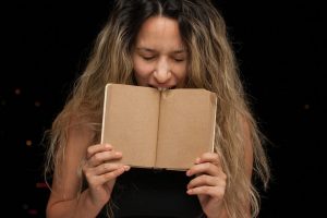 woman covering her face with brown book