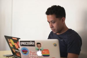 man in black crew neck t-shirt holding white laptop computer