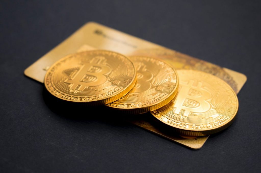 three round gold-colored Bitcoin tokens