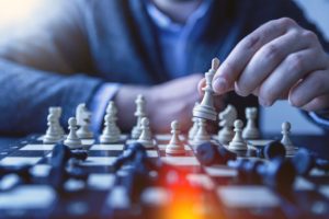 depth of field photography of man playing chess