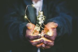 man holding incandescent bulb