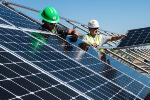 men holding solar panels