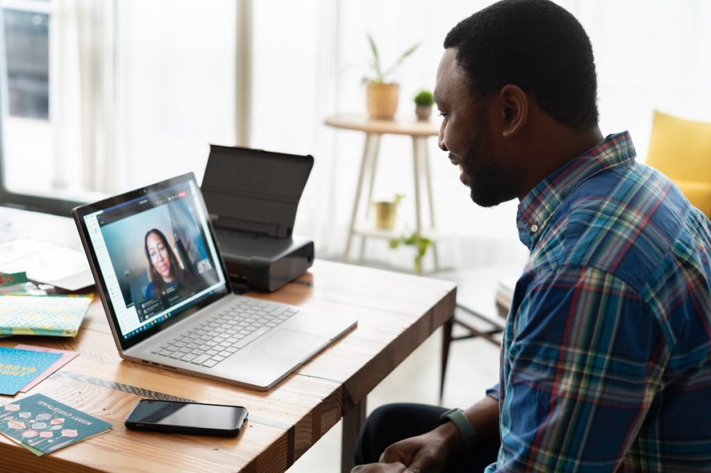 man in blue and white plaid dress shirt using macbook pro