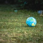 blue and white desk globe on green grass field during daytime