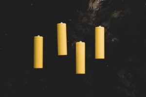 yellow pillar candles on black surface