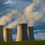 gray concrete towers under white clouds and blue sky during daytime